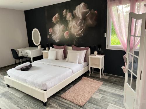 - une chambre avec un lit blanc orné d'une peinture murale dans l'établissement Chez Saliha et Serge, à Lamarche-sur-Saône
