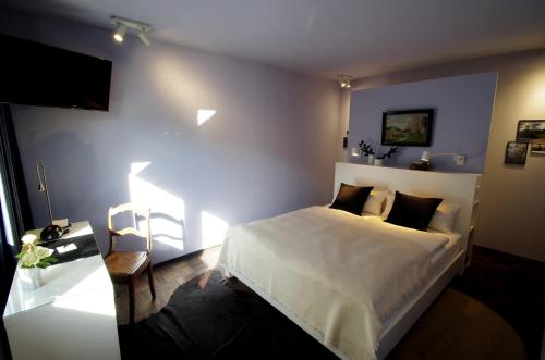 a bedroom with a white bed and a television at quartier26 in Nuremberg