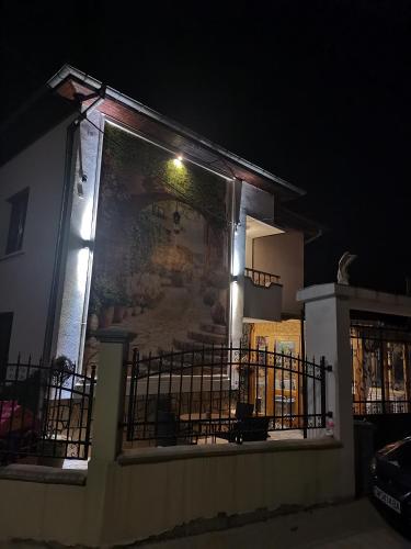 a building with a large mural on the side of it at night at Къща Томови,стаи за гости in Devin