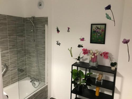 ein Badezimmer mit einer Dusche mit Blumen und Schmetterlingen an der Wand in der Unterkunft Sandy Eden Superieur in Drancy