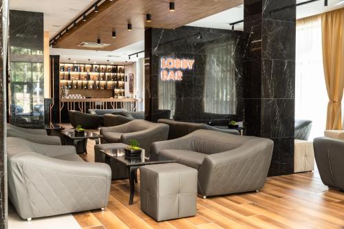 um átrio com sofás e mesas e um bar em Santé SPA Hotel em Velingrad