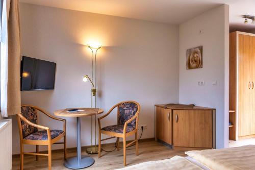 a room with a table and two chairs and a bed at Ferienanlage - Zum See & Hotel in Plau am See