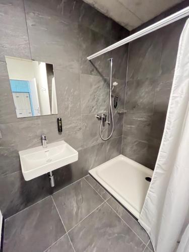 ein Badezimmer mit einem Waschbecken, einer Dusche und einer Badewanne in der Unterkunft Auberge de Jeunesse Saignelégier in Saignelégier