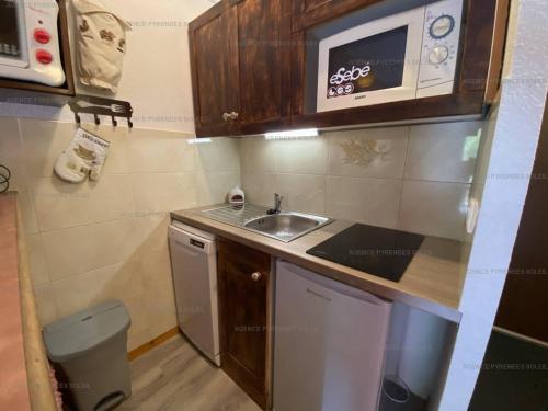 une petite cuisine avec un évier et un micro-ondes dans l'établissement Appartement T2 au pied des pistes, 4 couchages, Les Angles - Balcon, Wifi, Parking - FR-1-295-137, aux Angles