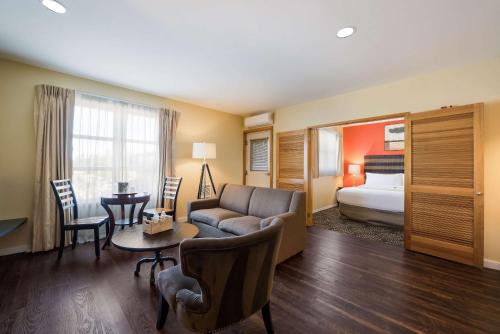 une chambre d'hôtel avec un canapé et un lit dans l'établissement Inn at Port Gardner-Everett Waterfront, Ascend Hotel Collection, à Everett