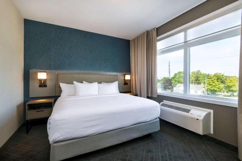 a bedroom with a large bed and a large window at Comfort Inn & Suites in Kingston
