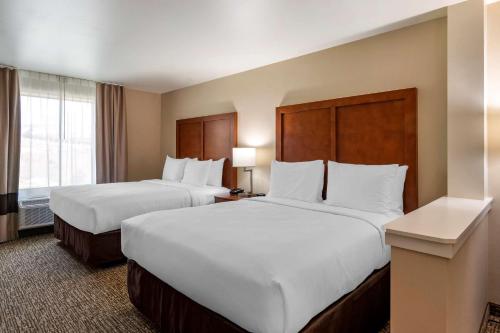 two beds in a hotel room with white pillows at Comfort Inn & Suites Charlottesville Hollymead Town Center in Charlottesville