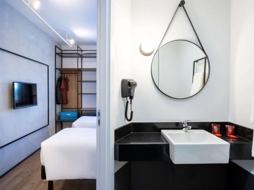 a bathroom with a sink and a mirror at ibis Botucatu in Botucatu