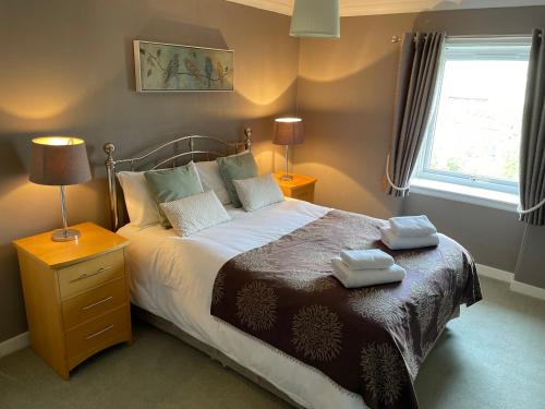 a bedroom with a bed with two towels on it at Hillview in Ballater