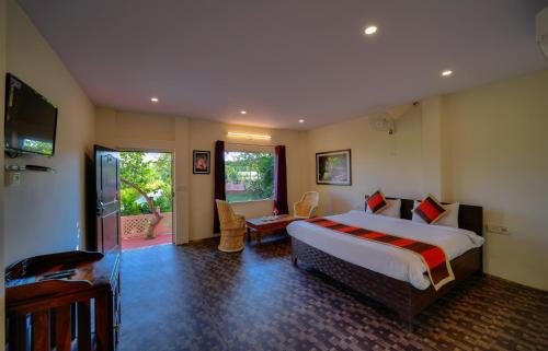 Dormitorio con cama, escritorio y TV en Ranthambore Nature Camp Resort en Sawāi Mādhopur