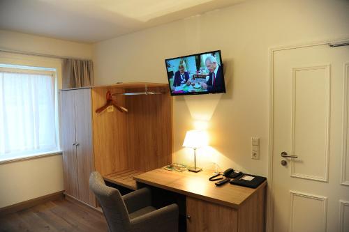 a room with a desk and a tv on the wall at Hotelanlage Starick in Lübbenau