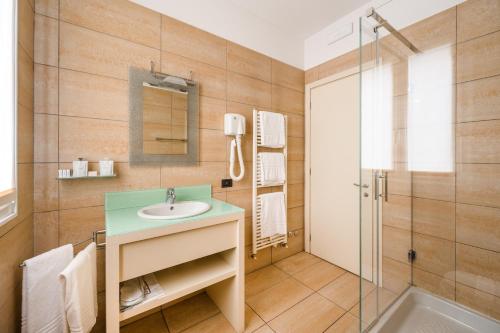 a bathroom with a sink and a shower at Hotel Cora in Carate Brianza