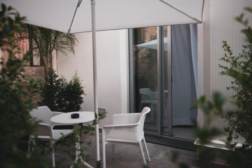 a patio with a table and chairs and an umbrella at MARINO WELLNESS in Ali Terme