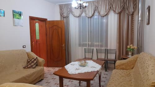 a living room with a couch and a table at Cortina House Berat in Kuçovë