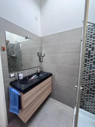 W łazience znajduje się umywalka i lustro. w obiekcie Villino Airport ciampino w mieście Marino