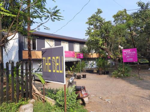 een bord voor een huis met een gebouw bij The Banyan Shelters Chondhi in Alibaug