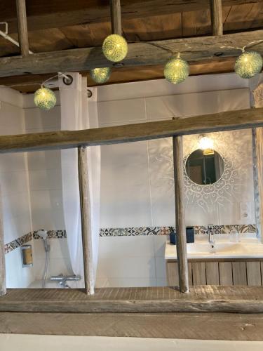 La salle de bains est pourvue d'un lavabo et d'un miroir. dans l'établissement Le Clos Bô-m, à Marignieu