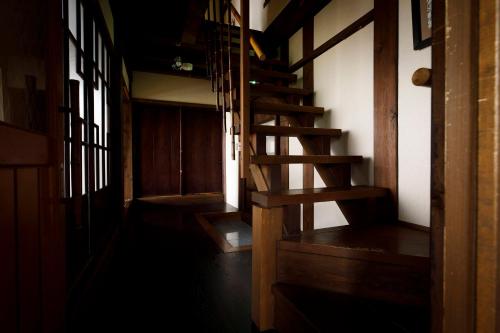 a hallway with a wooden staircase in a house at Busuitei in Hida