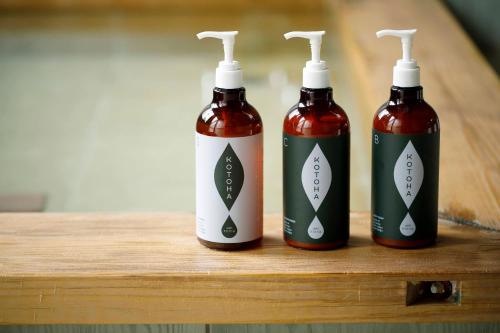 three bottles of liquid sitting on a wooden table at Busuitei in Hida