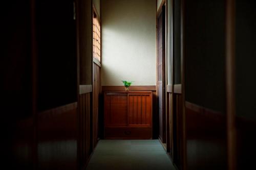 a hallway with a plant sitting on top of a table at Busuitei in Hida