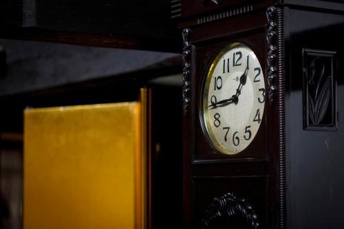 a grandfather clock is next to a yellow book at Busuitei in Hida