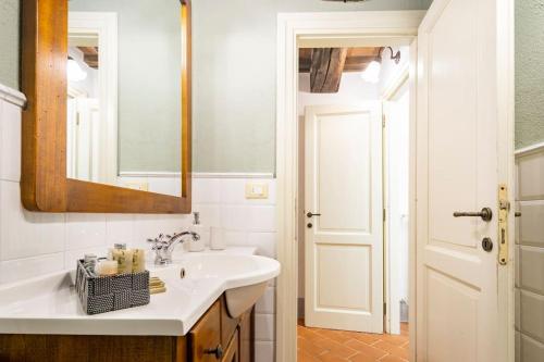 a white bathroom with a sink and a mirror at Vicolo Curtatone 30 in Foiano della Chiana