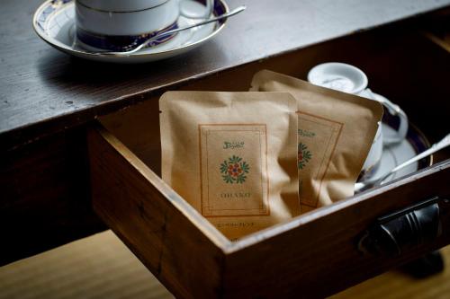 a wooden box with a cup of coffee on a table at Busuitei in Hida