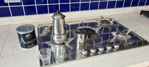 a kitchen sink with a stove and glasses in it at Adria Beach Apartment in Cavallino-Treporti