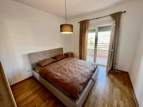 sypialnia z łóżkiem i dużym oknem w obiekcie Fanky City Apartments w mieście Podgorica