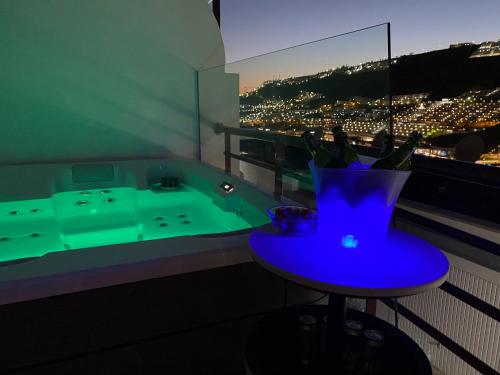 ein Badezimmer mit einer Badewanne und einem blauen Tisch mit einem lila Stuhl in der Unterkunft Villa Mogan Mall, con jacuzzi y PlayStation 5 in Puerto Rico de Gran Canaria