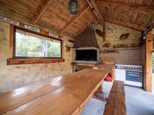 a large wooden table in a kitchen with a window at Cabana Barbu in Făgăraş
