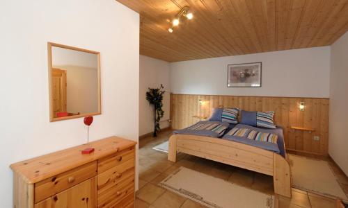 a bedroom with a bed with a mirror and a dresser at Ferienhaus zur Weinlaube in Thurmansbang
