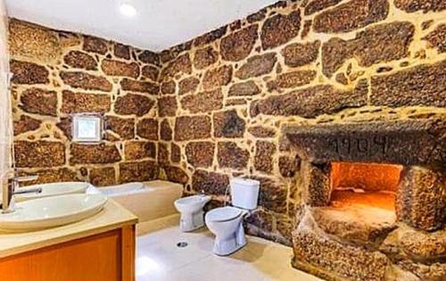 a bathroom with a stone wall with a fireplace at Beautiful 2-Bed House - Marco de Canaveses in Marco de Canaveses