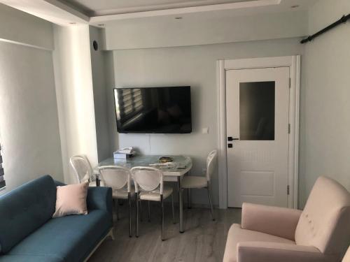 een woonkamer met een blauwe bank en een tafel bij Karakoçan Apart otel in Karakoçan
