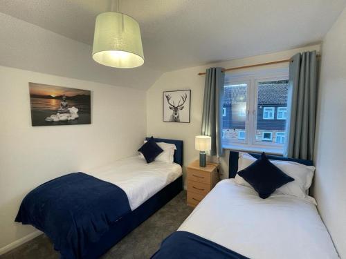 een slaapkamer met 2 bedden en een raam bij 3-bedroom home with free parking in Canterbury