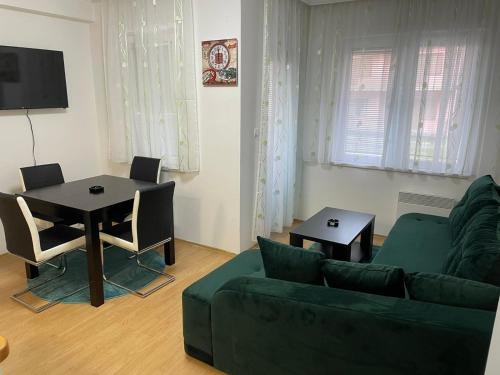 a living room with a green couch and a table at SIMIKIC Z in Bijeljina