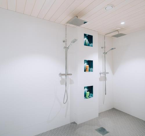 ロヴァニエミにあるVilla Snow Whiteの白いバスルーム(壁に絵画が飾られたシャワー付)