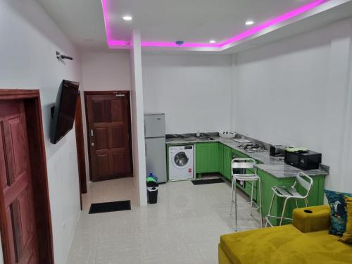 a kitchen with green cabinets and a purple light at Apex Boutique apartments in Georgetown