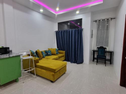 a living room with a yellow couch and blue curtains at Apex Boutique apartments in Georgetown