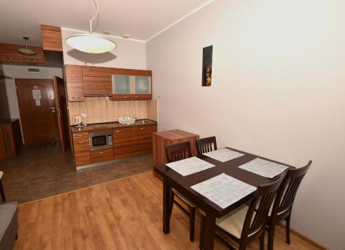 cocina y comedor con mesa y sillas en Apartament Mondi Kai II, piękna Willa przy szlaku na Szrenicę, mini SPA, en Szklarska Poręba