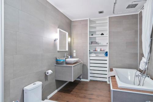 ein Badezimmer mit einem Waschbecken, einem WC und einer Badewanne in der Unterkunft Hotel Belle-Vie in Sint-Truiden