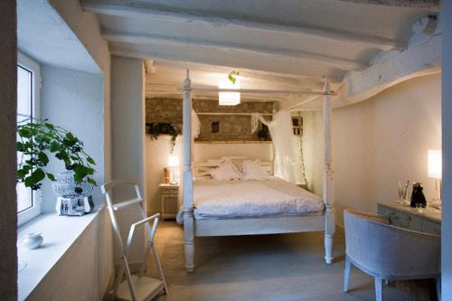 a bedroom with a canopy bed and a table and chairs at Hotel El Secreto de Ollo in Ollo