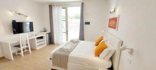 a bedroom with a bed and a desk and a television at Branco Suites - Rooms & Holiday Apartments in Santa Maria