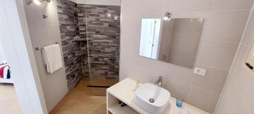 a white bathroom with a sink and a mirror at Branco Suites - Rooms & Holiday Apartments in Santa Maria
