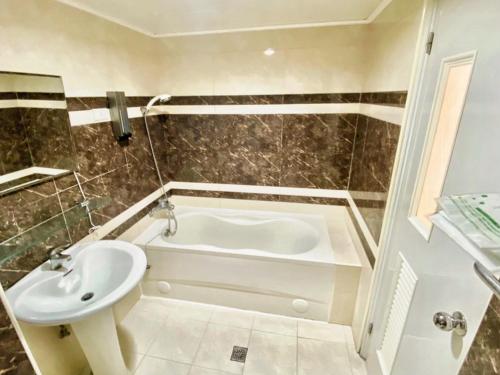 a bathroom with a white tub and a sink at Royal Business Hotel in Hsinchu City