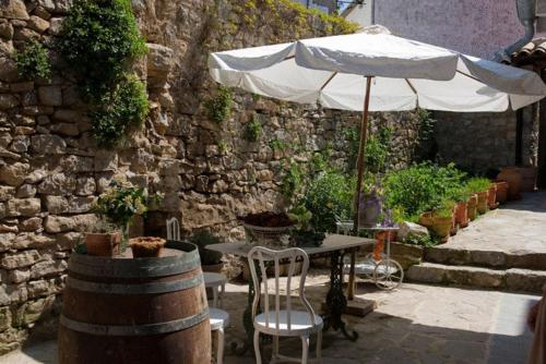 a table with an umbrella next to a stone wall at Hotel El Secreto de Ollo in Ollo