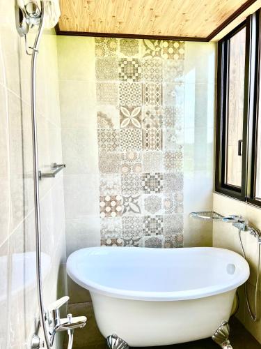 a bathroom with a white tub and a shower at Xin yi in Wujie