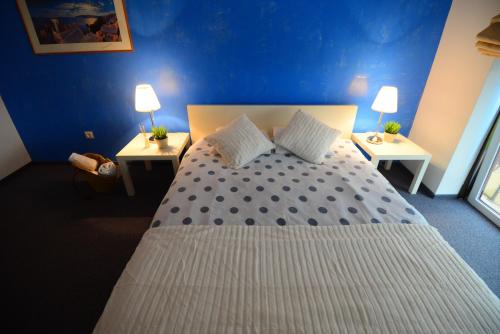 a bedroom with a large bed with two night stands at Hotel Biscuit in Cluj-Napoca