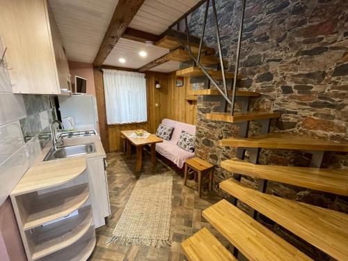 a kitchen and living room with a stone wall at Poilsis Preiloje-91 in Neringa