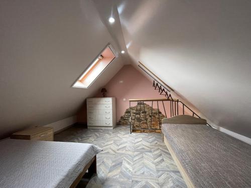 a attic bedroom with two beds and a window at Poilsis Preiloje-91 in Neringa
